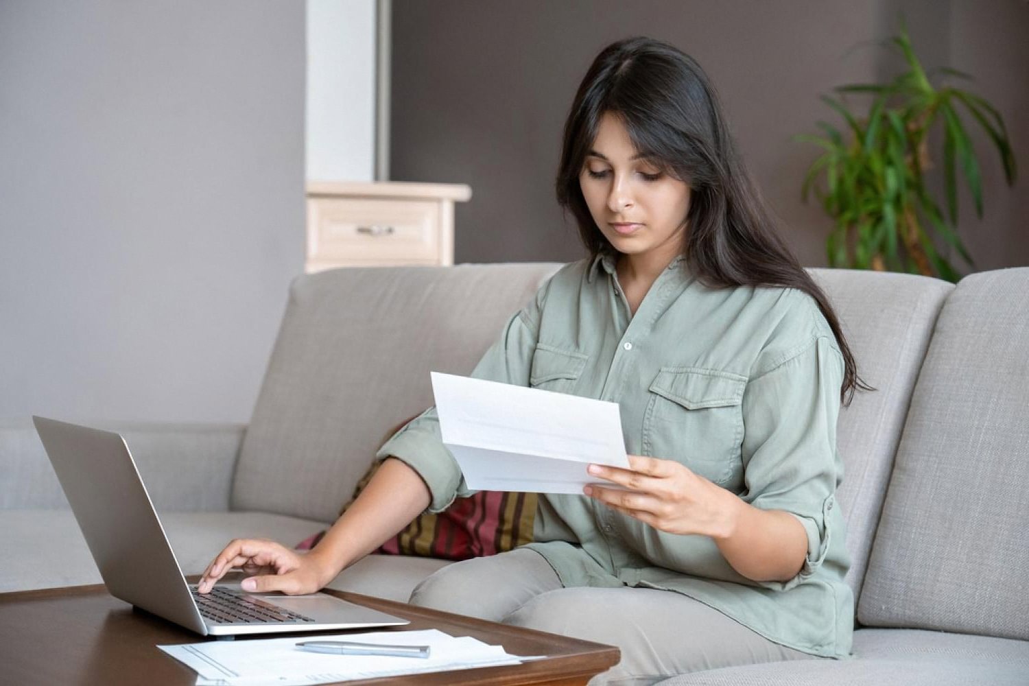Employee reviewing group life insurance policy documents on a laptop at home in the UAE